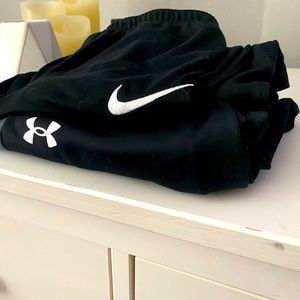 Two pairs of black pants boys size medium. One is under armor and the other Nike